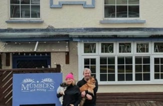 couple holding their dogs outside mumbles ale house 